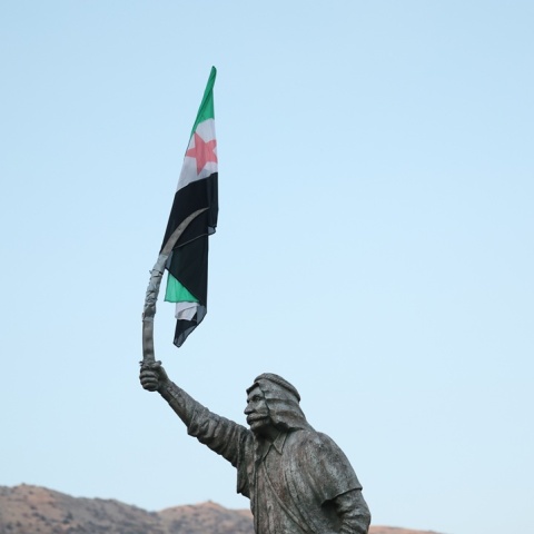 Η σημαία της συριακής αντιπολίτευσης κρέμεται από το ξίφος του αγάλματος του Δρούζου Σουλτάνου Αλ-Ατράς Πασάατ 