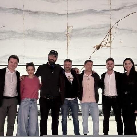 O σκηνοθέτης Ρομέν Γαβράς στα γυρίσματα της ταινίας με την Καλλιτεχνική Διευθύντρια και τον Γενικό Διευθυντή του Φεστιβάλ Αθηνών Επιδαύρου, Κατερίνα Ευαγγελάτου και Ιωάννη Καπλάνη, τον ιδρυτή και επικεφαλής της εταιρείας παραγωγής Heretic, Γιώργο Καρναβά, τον Διευθύνοντα Σύμβουλο ΕΚΚΟΜΕΔ, Λεωνίδα Χριστόπουλο και στελέχη του φορέα.