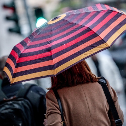 Γυναίκα με ομπρέλα προστατεύεται από τη βροχή