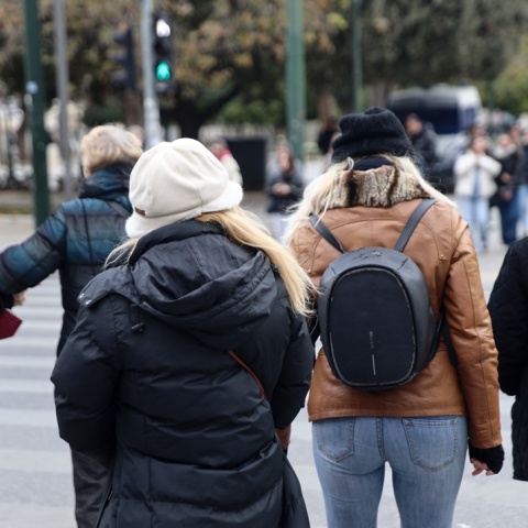 Πολίτες με βαριά, χειμωνιάτικα ρούχα σε δρόμο της Αθήνας