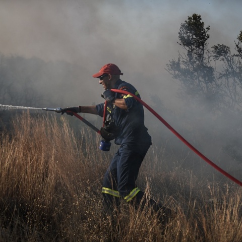 Πυροσβέστης με μάνικα ανά χείρας