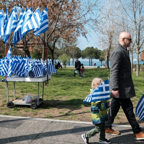 Παιδί με ελληνική σημαία και σταντ με σημαίες