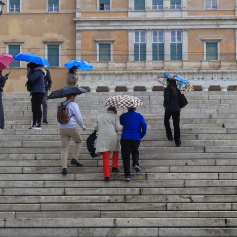 Πολίτες με ομπρέλες εν μέσω βροχής