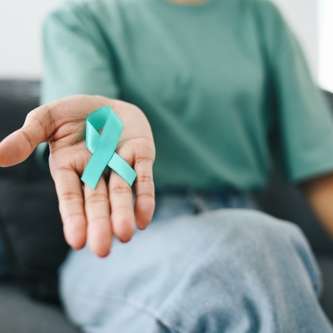 Γυναίκα κρατά φιόγκο για τον καρκίνο του τραχήλου της μήτρας