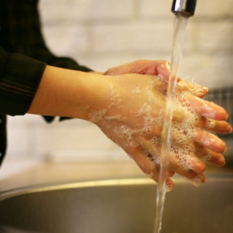 Άτομο πλένει τα χέρια του κάτω από τη βρύση