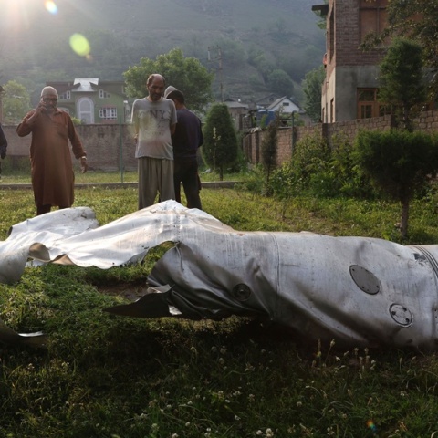 Άνθρωποι στέκονται κοντά στο κατεστραμμένο τμήμα ενός άγνωστου αεροσκάφους