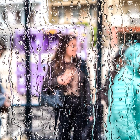 Πολίτες φαίνονται πίσω από βρεγμένο τζάμι