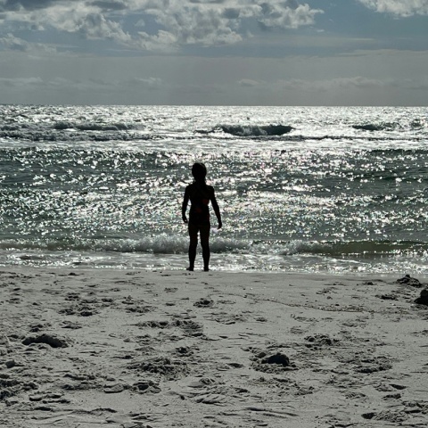 Παιδί στην άκρη της αμμουδιάς κοιτά την αγριεμένη θάλασσα