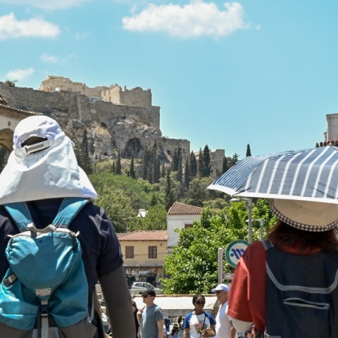 Πολίτες με καπέλα εν μέσω καύσωνα στο κέντρο της Αθήνας