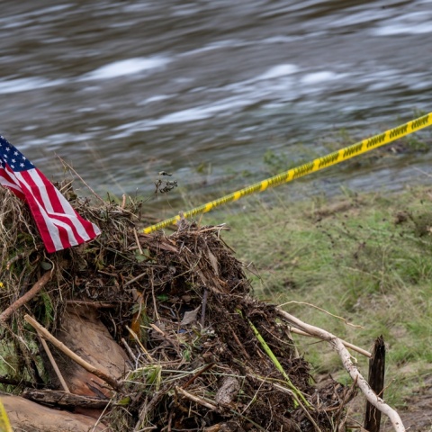 Φερτά υλικά κάνουν βουναλάκι δίπλα από πλημμυρισμένο χώρο στο Τέξας - Πάνω τους μία σημαία των ΗΠΑ