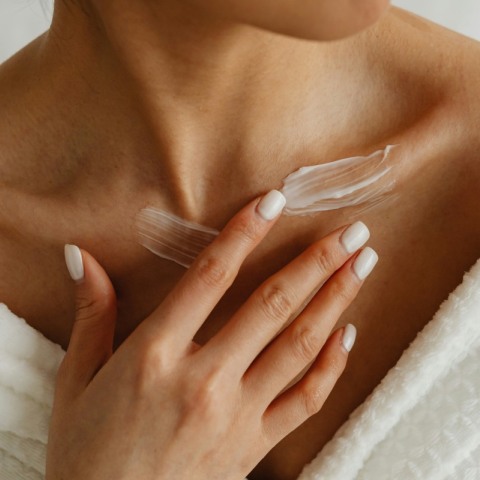 κοπέλα που απλώνει κρέμα στο σώμα 