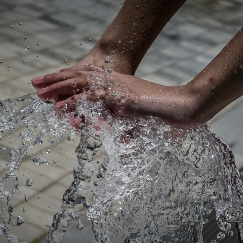 Χέρια παιδιού σε πήδακα νερού
