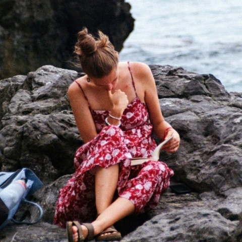 Κορίτσι που διαβάζει στην παραλία