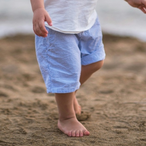 Πόδια παιδιού που περπατά στην άμμο