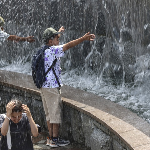 Άτομα αναζητούν λίγες στιγμές δροσιάς σε σιντριβάνι