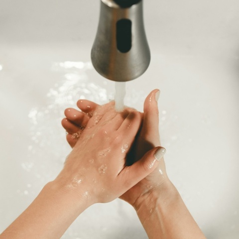 Άτομο που πλένει τα χέρια του κάτω από βρύση