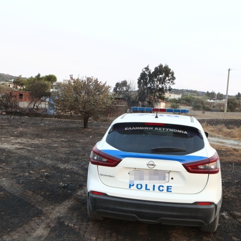 Περιπολικό της ΕΛ.ΑΣ. σε σημείο όπου έχει καεί από τη φωτιά στην Κερατέα