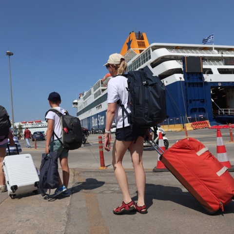 Ταξιδιώτες με τις βαλίτσες στο χέρι στο λιμάνι του Πειραιά