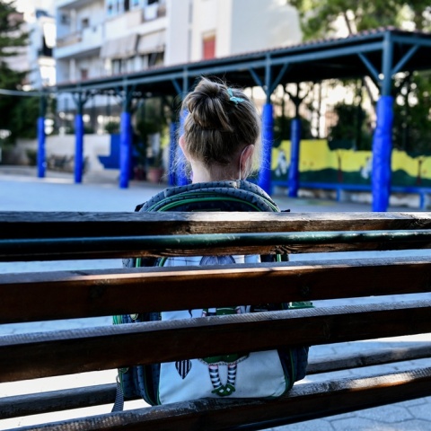 Μαθήτρια κάθεται μόνη της σε ένα παγκάκι στο προαύλιο σχολείου