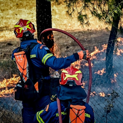 Πυροσβέστες με τις μάνικες επιχειρούν για την κατάσβεση φωτιάς