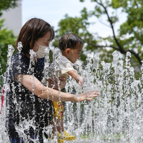 Μητέρα με το παιδί της στο Τόκιο αναζητούν λίγες στιγμές δροσιάς σε σιντριβάνι
