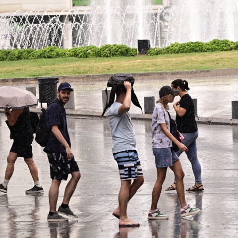 Πολίτες περπατούν εν μέσω βροχής