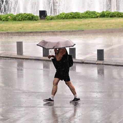 Άτομο με ομπρέλα εν μέσω βροχής στο κέντρο της Αθήνας