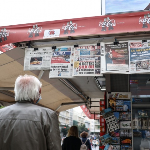 Άνδρας διαβάζει τις εφημερίδες που είναι κρεμασμένες σε περίπτερο