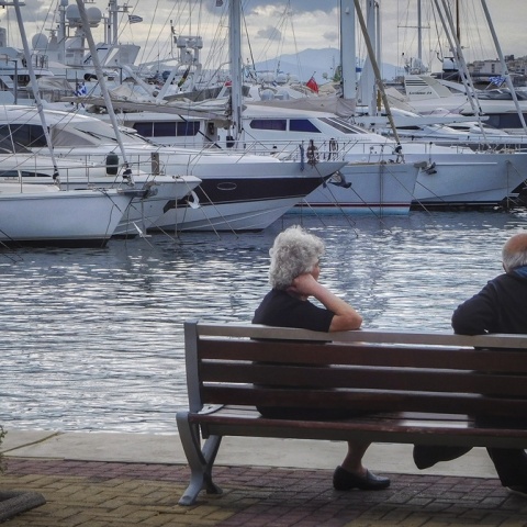 Συνταξιούχοι καθισμένο σε παραθαλάσσιο παγκάκι