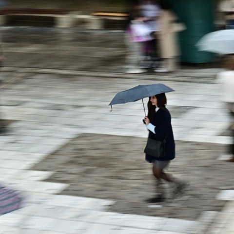 Κοπέλα με ζακέτα και ομπρέλα