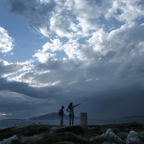 Δύο ατομα σε λόφο ενώ πίσω τους φαίνονται μαύρα σύννεφα