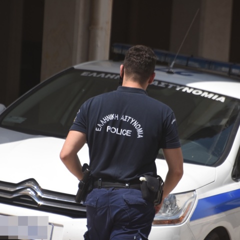 Αστυνομικός δίπλα από περιπολικό