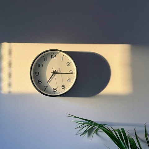 Ρολόι τοίχου που πέφτουν πάνω του ακτίνες του ήλιου