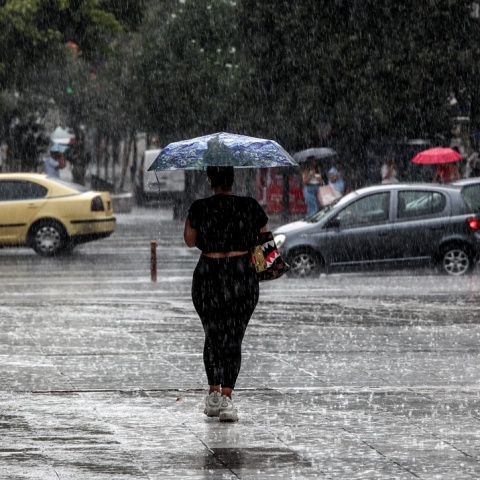 Γυναίκα με ομπρέλα εν μέσω καταιγίδας
