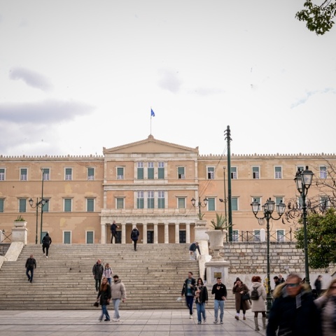 Πολίτες στην πλατεία Συντάγματος με φόντο τη Βουλή