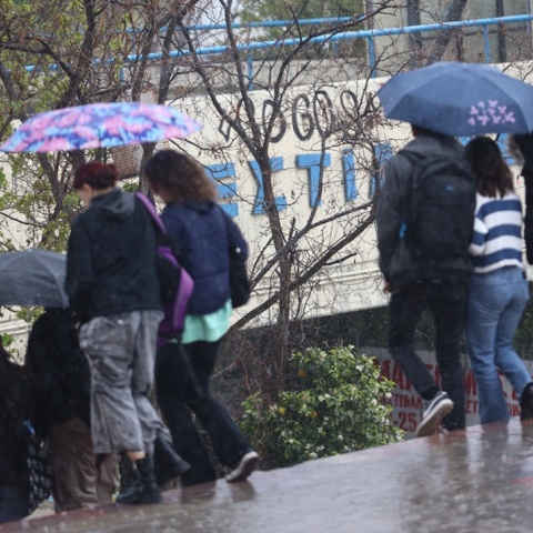 Πολίτες με ομπρέλες εν μέσω βροχής