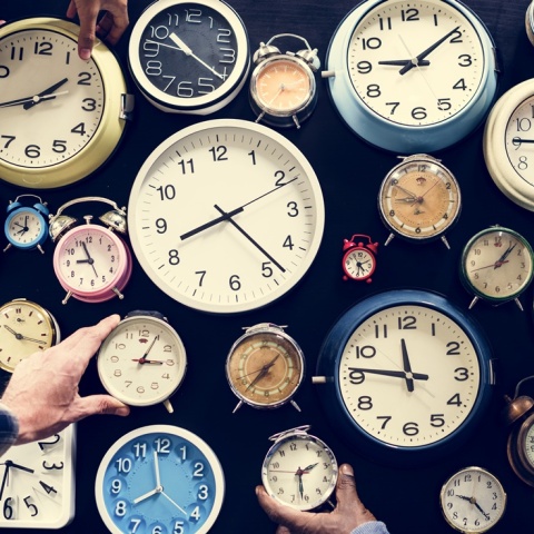 Ρολόγια πολλών σχημάτων και χρωμάτων και χέρια που επιδιώκουν να τα πιάσουν