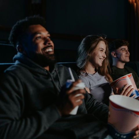 Άτομα σε σινεμά με ποπ κορν στα χέρια