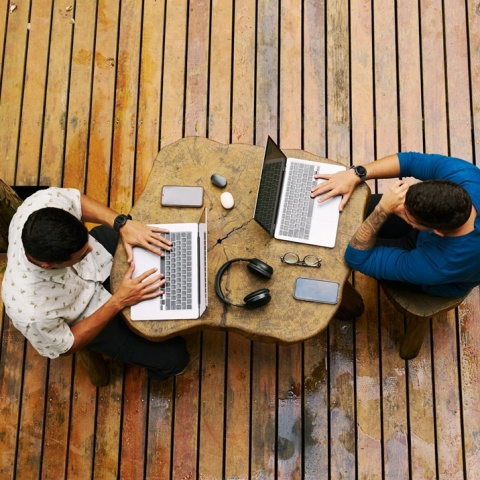 Δύο άνδρες που εργάζονται στα λάπτοπ τους