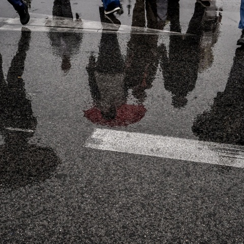 Αντικατοπτρισμός με ομπρέλες εν μέσω βροχής σε λίμνη νερού