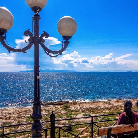 Κυρίες που κάθονται σε παγκάκι και αγναντεύουν τη θάλασσα