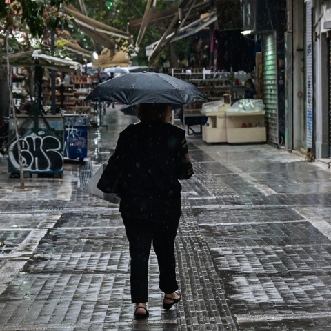 Άτομο με ομπρέλα περπατά εν μέσω βροχής