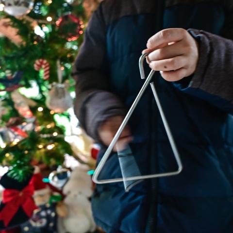 Παιδί με τρίγωνο λέει τα κάλαντα