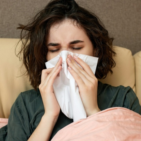 Άτομο σκουπίζει τη μύτη του με χαρτομάντηλα