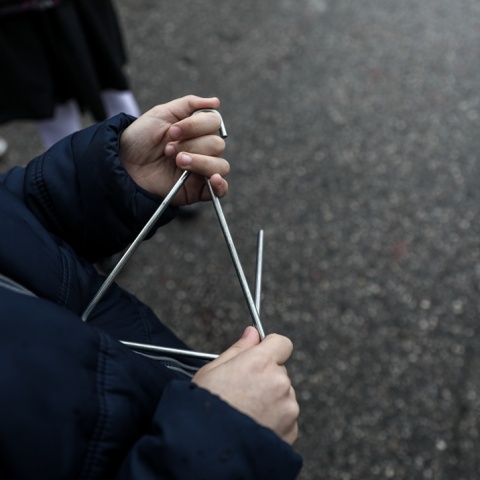 Παιδί που λέει τα κάλαντα με τρίγωνο στο χέρι