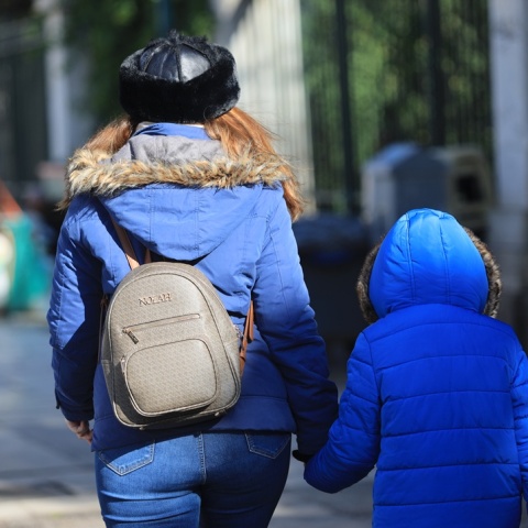 Παιδί με τη μητέρα του ντυμένοι με χοντρά, χειμωνιάτικα ρούχα