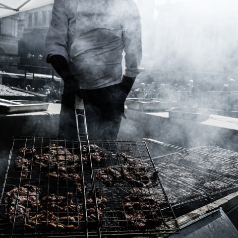 Άτομο ψήνει σε σκάρα και κάρβουνα  κρέας