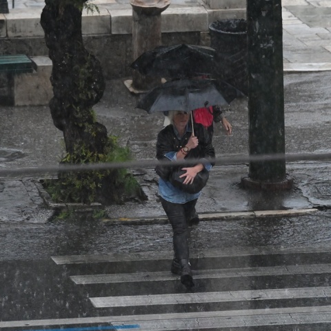 Πολίτες με ομπρέλες εν μέσω καταιγίδας