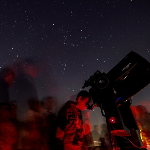 Πολίτες στον νυχτερινό ουρανό δίπλα σε τηλεσκόπιο για την παρακολούθηση πλανητών