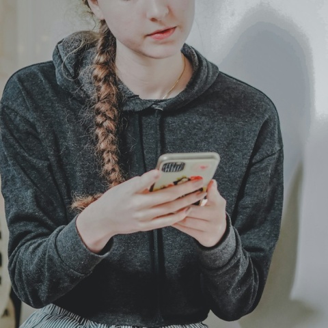 Ανήλικη με το κινητό στο χέρι